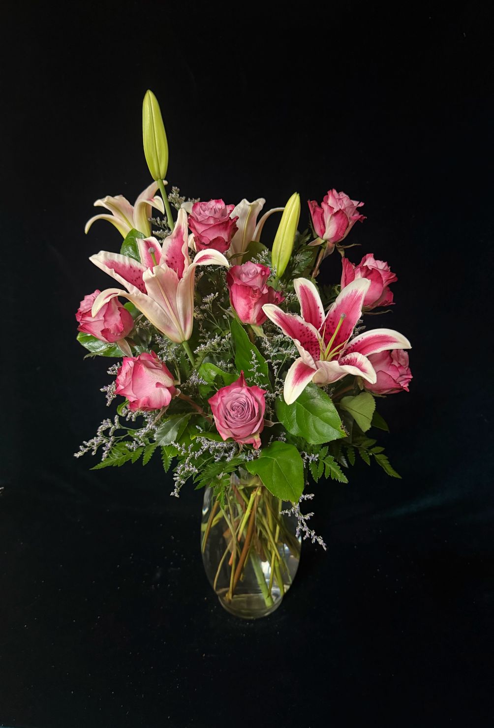 roses and lilies in clear vase 