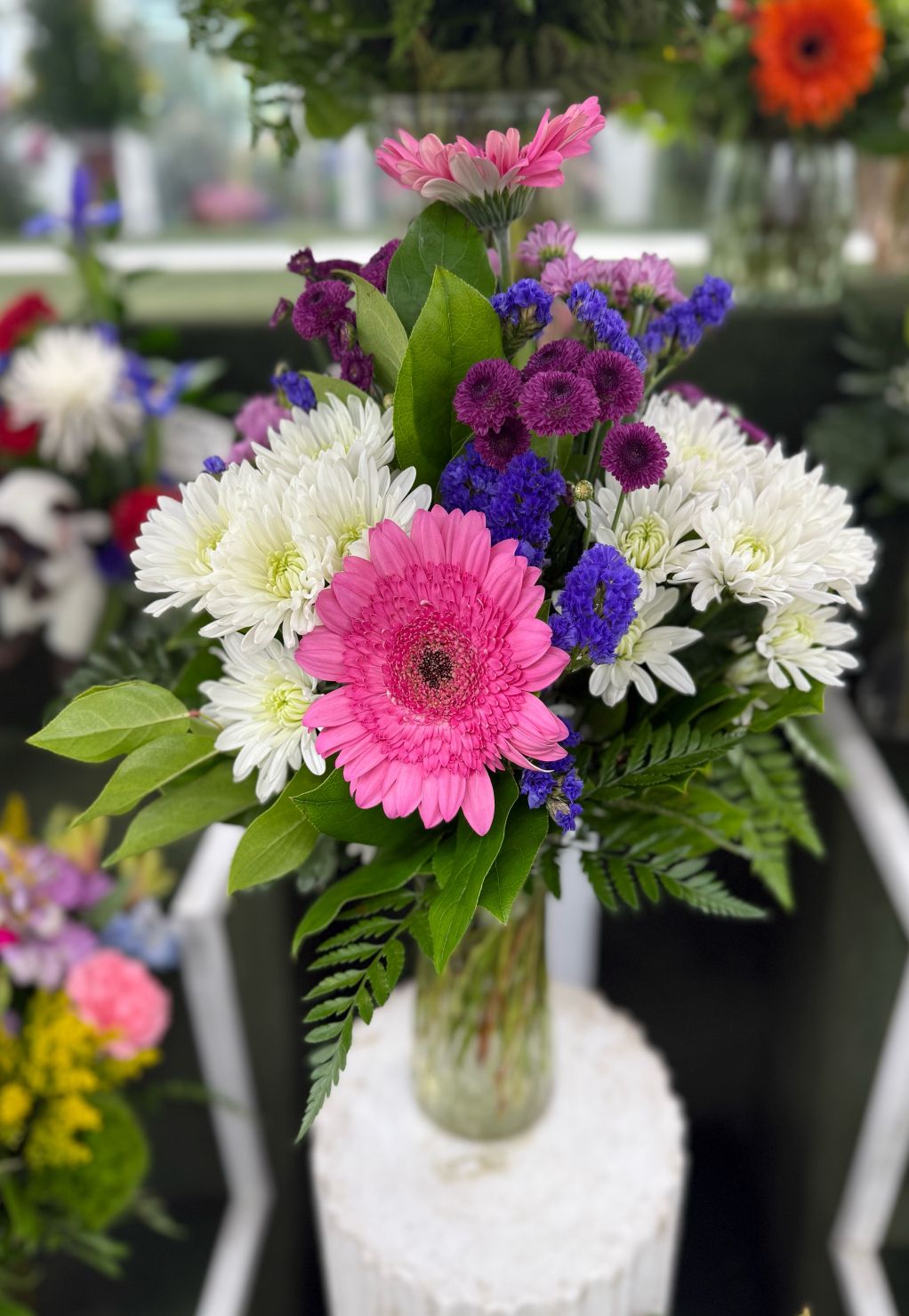 PINK WHITE & PURPLE GERBERA ARRANGEMENT IN THE COOLER 