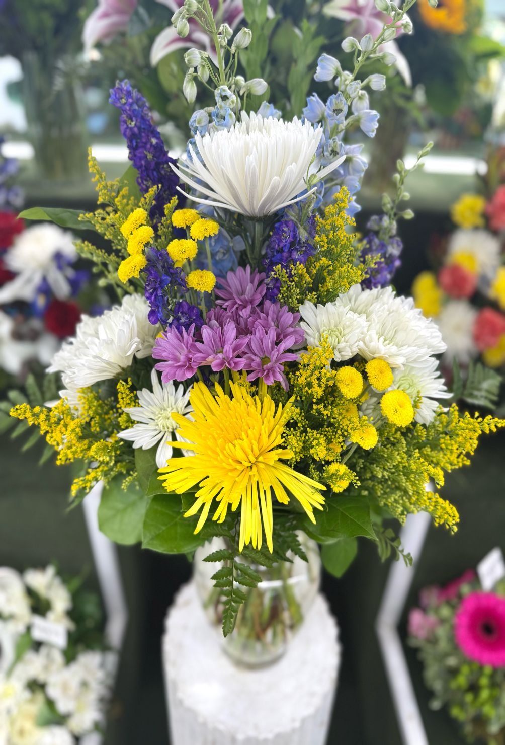 BRIGHT MIX OF YELLOW AND PURPLE ARRANGEMENT IN THE COOLER