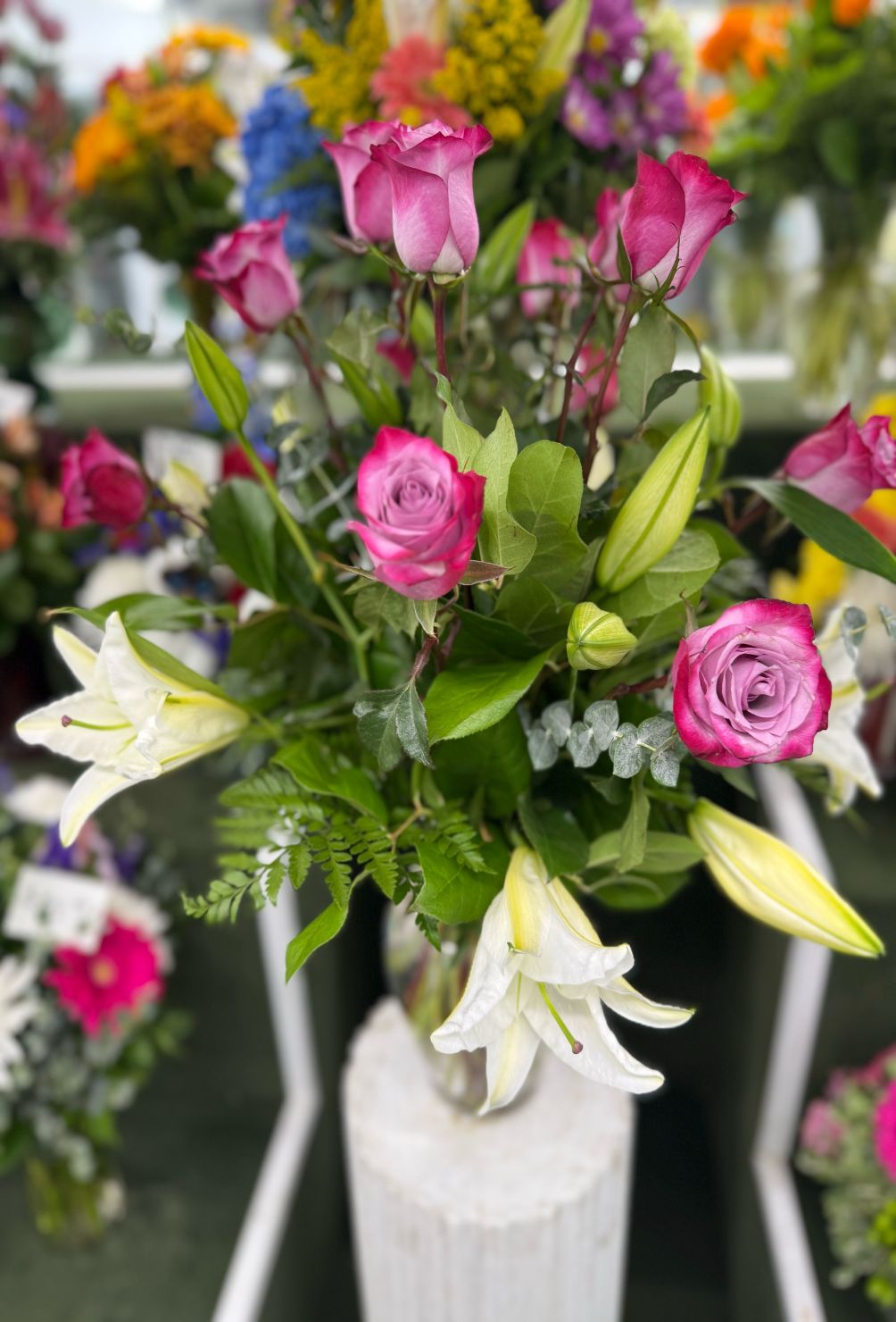 DOZEN LAVENDER ROSES AND WHITE LILY ARRANGEMENT IN THE COOLER