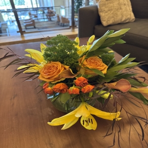 Dottie's Flowers and Plants Los Angeles - Bring the warmth of autumn indoors with this stunning, hand-tied bouquet of golden lilies and rich peach roses. 
Delicate ferns and textural accents create a captivating centerpiece, radiating cheerful energy and natural beauty. 
Perfect for brightening a room, expressing gratitude, or sending a thoughtful “thinking of you” gift to someone special.
This vibrant floral arrangement is a burst of sunshine, guaranteed to lift spirits and add a touch of elegance to any occasion.