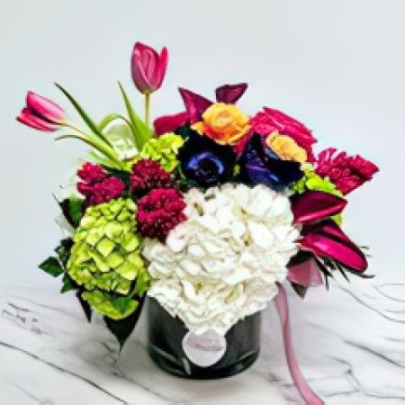 Beaverton Florists- Demo Beaverton - An exquisite blend of graceful Calla Lilies, opulent Hydrangeas, aromatic Hyacinth, and Roses, paired with charming Tulips, artfully arranged within a sleek, transparent glass cylinder.