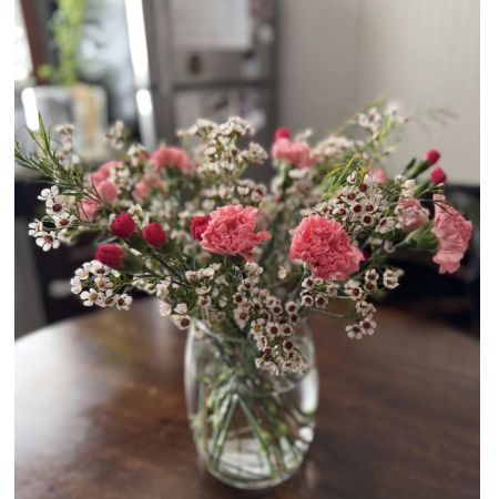 Beaverton Florists- Demo Beaverton - Delicate and charming, this hand-tied bouquet features vibrant pink carnations and rich red buds nestled among airy sprays of white waxflowers. Arranged in a clear glass vase, the display exudes freshness and heartfelt simplicity—perfect for brightening any room or celebrating life’s quiet, meaningful moments. Ideal for Mother’s Day, a thoughtful thank-you, or just because.