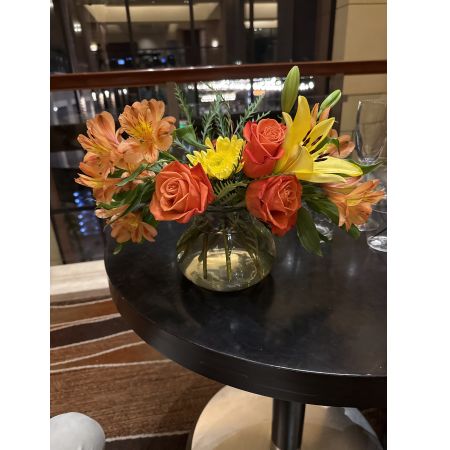 Beaverton Florists- Demo Beaverton - Brighten any space with this radiant bouquet of roses, lilies, alstroemeria, and chrysanthemums, a symphony of warm orange and sunny yellow hues. The captivating fragrance and vibrant colors evoke feelings of joy and optimism, perfect for celebrations or simply to uplift the everyday. Delivered in a charming glass vase, this fresh flower arrangement makes a thoughtful gift for any occasion – birthdays, anniversaries, or just because. Send a burst of sunshine and heartfelt emotion with this stunning floral display.