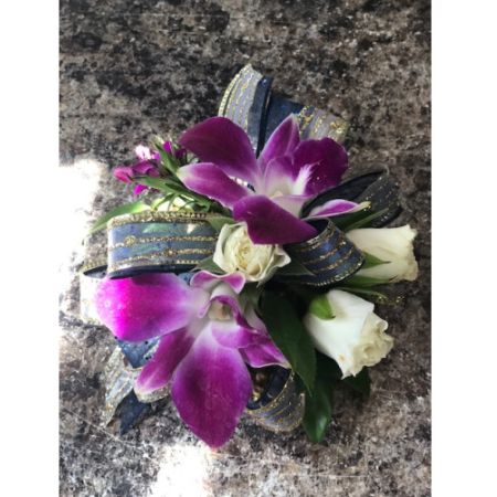 Flowers By Fairytales Elk Grove - This unique corsage features purple orchids and  white spray roses. Customers may choose the color of the flowers and ribbon.