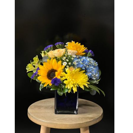 Fortin Gage Nashua - A flower arrangement reminiscent of the summer sky! Send bright sunny days ahead with blue hydrangea, sunflower, spray roses, and more!