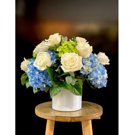 Fortin Gage Nashua - Invoking coastal charm, this arrangement is overflowing with hydrangea & a dozen white premium roses in a white glass cylinder.