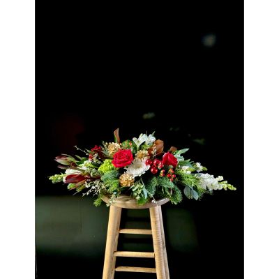 Fortin Gage Nashua - The finishing touch on your holiday table! A long and low centerpiece with velvety soft magnolia, gilded pine cones, several red roses and local Christmas greens and more 