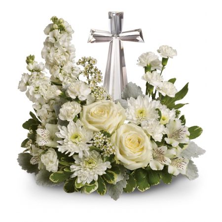 Madison Avenue Florist Sacramento -  Divine Peace Bouquet offers an elegant display of faith and tranquility to comfort the bereaved thoughtfully and respectfully. The arrangement features a beautiful crystal cross surrounded by a bed of lovely blossoms. Pure white blooms, including roses, alstroemeria, stock, carnations, and wax flowers, create a fragrant and serene composition. Accented with dusty miller and variegated pittosporum, this arrangement is presented around an exclusive GENUINE Crystal Cross keepsake. The Divine Peace Bouquet is a meaningful expression of sympathy and remembrance, providing solace during a challenging time. The approximate dimensions are 14 1/2 inches.