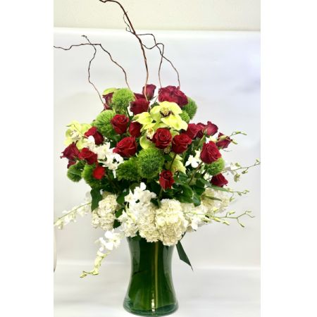 Conroy's Florist & Flower Delivery Mission Viejo - This breathtaking bouquet designed for Valentine's Day showcases lush scarlet roses, pristine white hydrangeas, and exotic green cymbidium orchids, all elegantly nestled in a glass vase with ti leaf accents. This romantic arrangement captures the essence of a secret garden, its vibrant hues and delicate blooms symbolizing deep love and admiration. The addition of ethereal green mist enhances its enchantment, making it an ideal gift for captivating the heart of your Valentine. Perfect for those seeking to express their love with a touch of elegance and whimsy.
