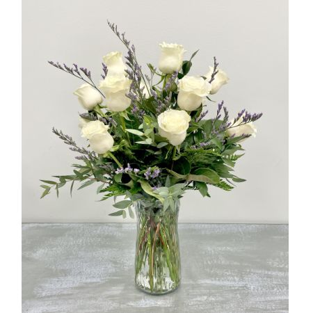 Tom's Florist Smyrna - Elegant and serene, this arrangement features one dozen premium white roses accented with delicate baby’s breath and fresh greenery, artfully arranged in a classic clear glass vase.

Symbolizing purity, grace, and remembrance, white roses make a beautiful gift for weddings, sympathy, or simply to convey heartfelt sentiments.

Includes vase and baby’s breath.