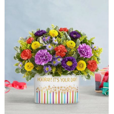 Tom's Florist Smyrna - Bursting with color and joy, the Hooray Bouquet is a celebration in full bloom. Designed to brighten any day, this vibrant arrangement features a lively mix of fresh, seasonal flowers in a playful palette of bold pinks, sunny yellows, cheerful oranges, and pops of purple.

It’s all presented in a festive ceramic container that adds a fun, celebratory touch—and makes a perfect keepsake long after the blooms have faded. Whether you’re marking a birthday, a milestone, or just sending a little joy "just because," the Hooray Bouquet says it all with style and a smile.