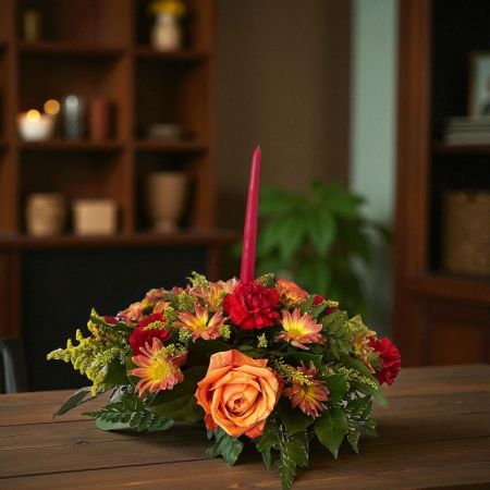 Tom's Florist Smyrna - Bring the warmth of fall to the table with our beautiful Autumn Centerpiece. This seasonal arrangement features a lovely mix of autumn flowers and fall accents arranged around a candle in the center, creating a warm and inviting display.

Perfect for a Thanksgiving table, autumn dinner, or simply adding a touch of seasonal color to the home, this centerpiece combines the beauty of fresh flowers with the cozy glow of candlelight. It also makes a thoughtful gift for anyone who loves decorating their home for the fall season.