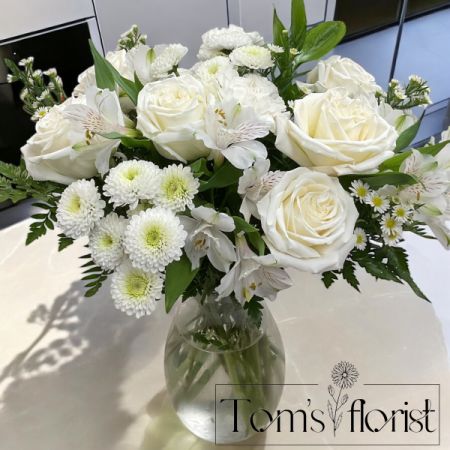 Tom's Florist Smyrna - A graceful expression of beauty, Elegant Blooms features a lush blend of all-white florals thoughtfully arranged to bring comfort, peace, and timeless charm. Designed in a large, full presentation, this arrangement includes a seasonal mix of elegant blooms like roses, alstroemeria, carnations, and more — all in pure white tones that reflect calm and heartfelt sentiment.

Whether you're sending love just because, celebrating a special moment, or offering your condolences, Elegant Blooms speaks with quiet elegance and care.
