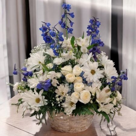 Tom's Florist Smyrna - Share a moment of quiet beauty with the Harmony Garden Basket—a charming arrangement designed to bring balance, warmth, and thoughtful cheer to any setting.

Presented in a natural wicker basket, this graceful design features soft blue delphinium, delicate spray roses, cheerful daisies, and vibrant alstroemeria. The mix of textures and tones creates a garden-like feel that’s both comforting and uplifting, making it a perfect gift for sympathy, get well, or everyday moments of connection.

The Harmony Garden Basket offers a gentle reminder that beauty and peace can bloom in any season.