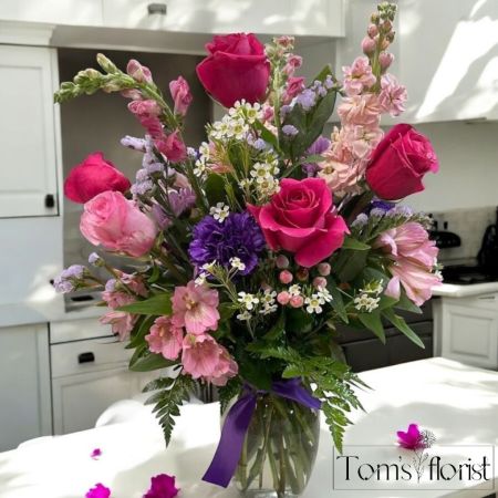 Tom's Florist Smyrna - Let your loved one know just how much they mean to you with "Love You Always"—a stunning floral arrangement designed to convey love, appreciation, and beauty in every season. This large bouquet features a harmonious blend of soft pinks and purples, combining luxurious roses, sweet carnations, delicate alstroemeria, airy wax flower, vibrant statice, and striking snapdragons.

The diverse mix of flowers creates a rich and textured display that radiates elegance and warmth, making it the perfect gift for any occasion—be it a birthday, anniversary, or simply to brighten someone’s day.

Whether celebrating a special moment or offering a thoughtful gesture, this arrangement serves as a timeless reminder of love that will never fade.