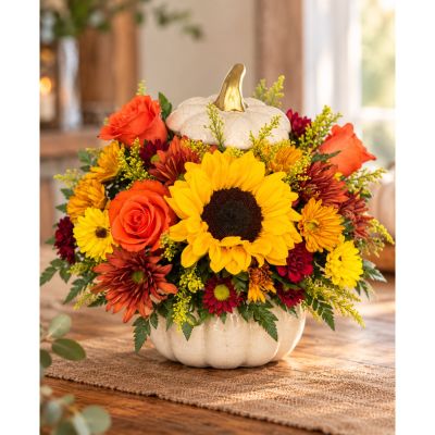 Tom's Florist Smyrna - EXCLUSIVE A plentiful mix of blooms gives our autumn arrangement an undeniable charm. Loosely gathered in fall tones, it’s the perfect contrast to our modern-styled pumpkin. Featuring a white satin finish, crackle detail and rich golden accents, this harvest-inspired container is perfect for repurposing.