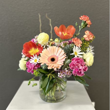 Conroy's Flowers San Diego San Diego - An elegant medley of hand-selected blooms, this arrangement pairs soft blush gerberas, vibrant tulips, and delicate carnations with fresh greenery, all artfully styled in a clear glass vase. Refined yet radiant, it brings a touch of effortless luxury and timeless beauty to any space.