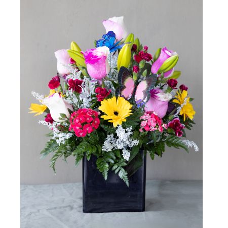 Conroy's Flowers El Cajon El Cajon - Immerse yourself in the enchanting "Butterfly Garden Symphony" floral arrangement. Set in a stylish black square vase, this vibrant creation captures the charm of a blooming butterfly garden. Delicate hues of yellow, pink, and soft white dance together, while enchanting butterfly decorations flutter in delight. Embrace the essence of spring and summer with this captivating centerpiece that brings the magic of a butterfly garden to life. With our same-day flower delivery, you can promptly share the beauty and whimsy of the "Butterfly Garden Symphony" with your loved ones, making any occasion more special.






