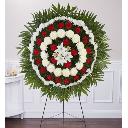 Conroy's Flowers El Cajon El Cajon - Celebrate the eternal nature of a loved one's essence with the Circle of Life™ Standing Spray. This standing spray is a symbolic representation of the infinite cycle of life. Crafted with alternating rows of fresh red and white blooms, it features a cluster of beautiful white lilies gathered at the center. The arrangement is accented by a frame of fresh palm fronds, creating a truly sacred and impressive display. The thoughtful design and meaningful symbolism make the Circle of Life™ Standing Spray a fitting tribute for honoring the memory of your loved one during funeral services.