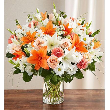 Conroy's Flowers El Cajon El Cajon - Convey your sincerest feelings in a time of loss with "Sincerest Sorrow Peach Orange and White." This bountiful and warm-hued bouquet features a lovely mix of peach roses, white lilies, and orange carnations. It is hand-designed inside a classic clear glass vase, making it a genuinely heartwarming gesture when sent to a service or the home of family or friends. With our same-day flower delivery, you can promptly express your condolences and offer comfort to those grieving. "Sincerest Sorrow Peach Orange and White" is a thoughtful and heartfelt arrangement that brings warmth and solace during difficult moments.