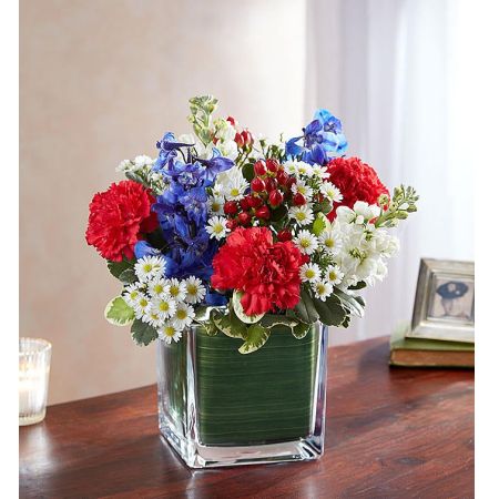 Conroy's Flowers El Cajon El Cajon - Celebrate and honor the memory of someone who held their country dear with "Soothing Sorrows Red White Blue." This patriotic sympathy arrangement features red roses, white stock, and blue delphinium, expertly gathered in a clear glass cube lined with Ti leaf ribbon. It serves as a respectful and exquisite gesture of comfort and healing. With our same-day flower delivery, you can promptly express your condolences and pay tribute to a patriotic soul. "Soothing Sorrows Red White Blue" is a thoughtful and dignified way to convey sympathy during difficult times, combining the beauty of flowers with a patriotic homage.





