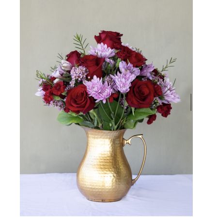 Conroy's Flowers El Cajon El Cajon - Experience the opulence of "The Gold Splendor" – a stunning floral arrangement featuring gorgeous tones of red and purple, meticulously designed onto a golden pitcher. This exquisite item is not only a visual delight but also a thoughtful gesture that is sure to make someone's day truly special.With our same-day flower delivery, you can promptly share the richness and beauty of "The Gold Splendor" with your loved ones, adding a touch of luxury to any occasion. It's a perfect choice to convey your warm wishes and bring joy to someone's heart with the radiant colors and elegant design of this unique arrangement.