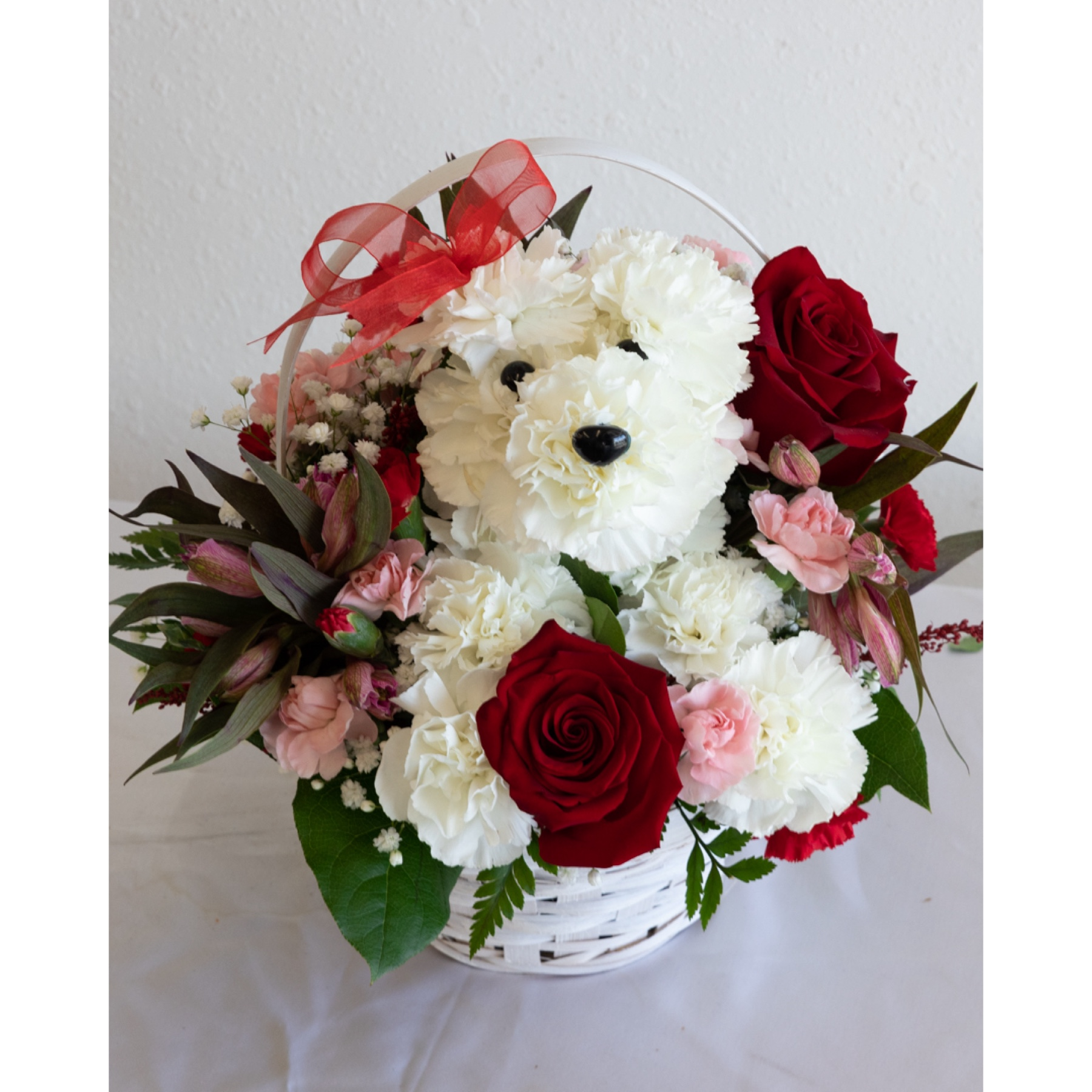 Conroy's Flowers El Cajon El Cajon - Introducing "Puppy Love EXCLUSIVE" – a delightful expression of affection! Crafted from lasting white carnations, our adorable canine cutie sits pretty in a dog bed basket, surrounded by a heartwarming mix of red and pink blooms. This exclusive arrangement is the perfect pick to spark romance or celebrate a special relationship. With our same-day flower delivery, you can promptly share this charming and unique expression of love, bringing the joy of "Puppy Love EXCLUSIVE" to your special moments. Whether it's a romantic gesture or a celebration of a cherished relationship, this arrangement is sure to melt hearts.






