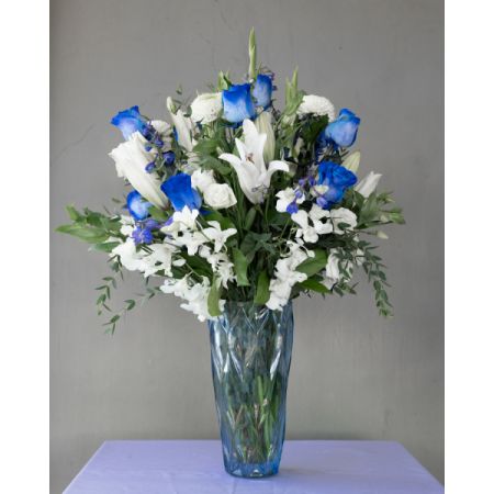 Conroy's Flowers El Cajon El Cajon - Experience the mesmerizing allure of winter with our 'Chilled Sapphire Glow.' This enchanting arrangement captivates with serene blues and whites, evoking a frost-kissed ambiance. Embrace the season's elegance and radiate a serene winter wonderland in your space.