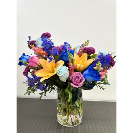 Conroy's Flowers El Cajon El Cajon - The Once Upon a Flower arrangement is a captivating display of blue, orange, lavender, and pink blooms, artfully assembled in a chic glass vase. Standing 14 inches tall and 12 inches wide, this distinctive bouquet adds a touch of enchantment to any setting. 

Please note: Depending on seasonal availability, flower varieties may vary, but the overall design and theme will remain consistent.