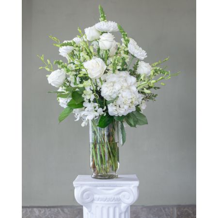 Conroy's Flowers El Cajon El Cajon - Experience the timeless elegance of the "Classic All White Arrangement." White flowers, with their timeless beauty, offer comfort during life's difficult moments. Hand-gathered by our caring florists with touches of lush greenery, this classic arrangement is a beautiful and heartfelt way to convey your condolences. With our same-day flower delivery, you can promptly express your sympathy and provide a source of solace to those in need. The "Classic All White Arrangement" is a thoughtful and serene expression of condolences, bringing a sense of comfort and elegance to difficult times.