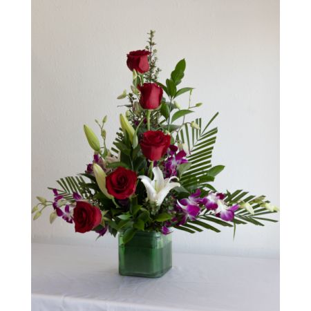 Conroy's Flowers El Cajon El Cajon - Ignite passion with 'Tropical Passion.' A blend of red, white, and purple blooms adorns a sleek glass cube. The picture represents the theme; different blooms and containers may be used based on availability, ensuring a unique and romantic expression for your Valentine's celebration.