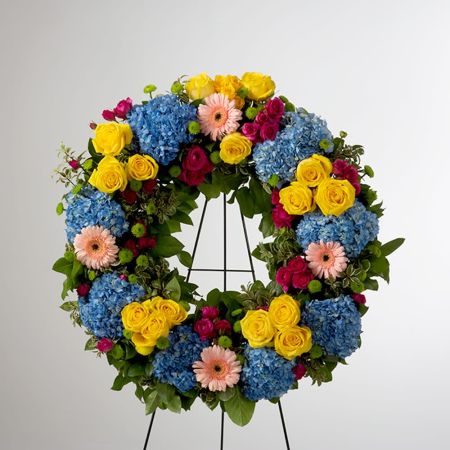Morningside Florist Rancho Cordova - This colorful and bright wreath spray is representative of a life lived to its fullest. Colors and Flowers may change based off of season and availability.