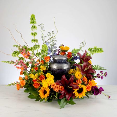 Morningside Florist Rancho Cordova - This colorful arrangement cradles the urn in a vibrant embrace. Colors and flowers may change based off of season and availability.
