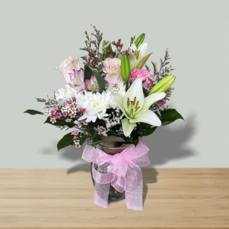 Blooms of Wayne Wayne - Make a stunning entrance with 'Arrive in Style', a captivating bouquet of fresh lilies, roses, and carnations in soft shades of pink and white. 
Delicate alstroemeria and waxflower add texture and a sweet fragrance, beautifully presented in a glass vase tied with a sheer pink ribbon.
Perfect for birthdays, anniversaries, or simply to brighten someone’s day, this elegant flower arrangement speaks volumes of love and admiration.
Send a touch of grace and sophistication with this unforgettable gift—a truly beautiful expression of your feelings.