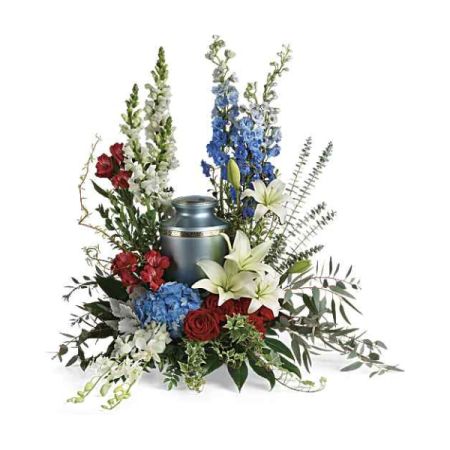 Blooms of Wayne Wayne - Reflections of Honor is a stunning tribute, a heartfelt expression of remembrance featuring vibrant red roses, delicate white lilies, and patriotic blue delphinium. 
This beautiful funeral flower arrangement surrounds a keepsake urn with lush greenery and textural stock, creating a serene and dignified display. 
Send comfort and show your deepest sympathy with this elegant sympathy arrangement, perfect for memorial services or expressing condolences.
A lasting symbol of respect, Reflections of Honor embodies grace and enduring love during times of loss and mourning.