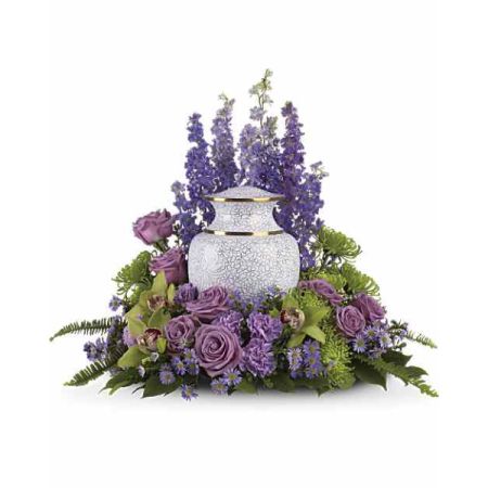 Blooms of Wayne Wayne - Capture a comforting tribute with 'Meadow of Memories', a serene arrangement of lavender roses and delicate purple stock. 
Soft hues of lilac and plum evoke feelings of peace and remembrance, beautifully surrounding a keepsake urn. 
Fresh greenery and orchids add a touch of natural elegance, creating a heartfelt expression of sympathy and love.
Send this stunning <b>funeral flower arrangement</b> to honor a life well-lived and offer solace during a difficult time.