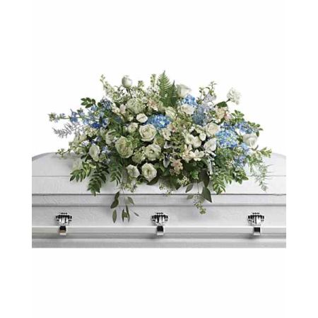 Blooms of Wayne Wayne - Offer a comforting embrace with ‘Tender Remembrance’, a beautiful casket spray designed to honor a life beautifully lived.
Soft whites and gentle blues of roses, hydrangeas, and delicate blooms cascade with graceful ferns, evoking serenity and peace.
This exquisite funeral flower arrangement speaks volumes when words feel insufficient, expressing deepest sympathy and heartfelt condolences. 
Send a lasting tribute of love and respect with this stunning display, a poignant expression of remembrance during a difficult time.