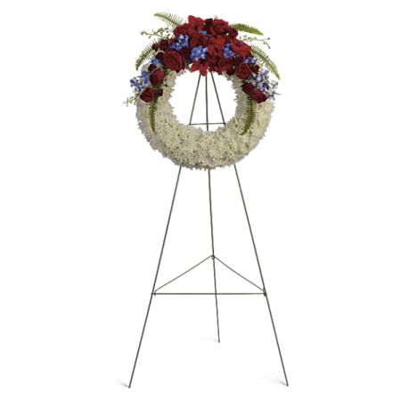 Blooms of Wayne Wayne - 'Reflections of Glory' is a stunning standing wreath, a heartfelt expression of sympathy and remembrance. Deep crimson roses and delicate blue blooms are gracefully embraced by a cloud of pristine white carnations and lush greenery. This beautiful funeral wreath offers a comforting tribute, radiating peace and honor during times of loss. Send a lasting and elegant symbol of your deepest condolences with this impactful flower arrangement.