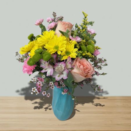Blooms of Wayne Wayne - Capture the effortless joy of a sunny afternoon with “A Walk In The Park” – a vibrant bouquet brimming with fresh daisies, sweet stock, and blushing roses.  
Delicate alstroemeria and carnations add a touch of whimsical color, nestled amongst lush greenery in a charming turquoise vase. 
This cheerful arrangement is perfect for brightening any room or sending a burst of happiness to someone special—a little piece of springtime delivered.
Send flowers today and share the simple pleasure of nature's beauty with this stunning mixed flower bouquet.