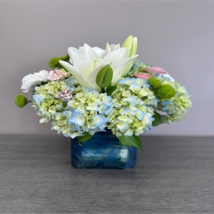 Blooms of Wayne Wayne - Bring the tranquility of a sun-kissed shoreline to any space with 'Beach Day'. This captivating arrangement evokes the feeling of warm sand between your toes and the gentle rhythm of ocean waves. Soft textured blooms in shades of creamy white delicate blush and calming seafoam green are expertly arranged to mimic the natural beauty of the coast. Imagine the subtle fragrance filling a room creating a peaceful escape – perfect for a comforting gesture a thank you gift or simply to brighten your own home. 'Beach Day' is more than flowers; it's a moment of serenity beautifully presented. These long-lasting blooms will provide joy for days reminding the recipient of carefree summer breezes and idyllic coastal views.