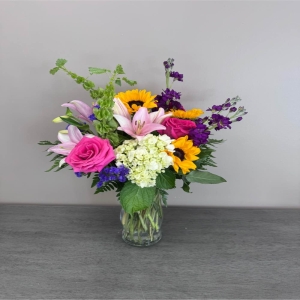 Blooms of Wayne Wayne - Breathe in the sunshine with 'Summer Vibing' a vibrant bouquet designed to capture the effortless joy of long summer days. This stunning arrangement bursts with the relaxed energy of the season offering a cheerful splash of color and fragrance to any space. Imagine the delicate scent of lilies and the playful pops of sunflowers brightening your kitchen table or the delighted smile of a loved one as they receive this thoughtful gift. 'Summer Vibing' isn’t just flowers; it’s a feeling – a little piece of happiness delivered straight to their door. Perfect for birthdays thank you gifts or simply to spread some warmth this bouquet embodies the carefree spirit of summer. Order yours today and let the good times bloom!