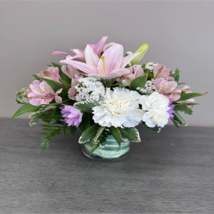 Blooms of Wayne Wayne - Send a moment of pure grace with 'A Simple Gesture'. This beautifully curated arrangement speaks volumes without saying a word. Soft blush-toned roses unfurl alongside delicate lilies creating a haven of tranquility and gentle fragrance. The sprigs of alstroemeria add a playful touch while the lush greenery provides a grounding balance. Imagine this bouquet brightening a loved one’s day offering comfort during a difficult time or simply celebrating the small joys in life. It's the perfect way to show you care express sympathy or offer a heartfelt ‘thank you’. A truly elegant and understated display of affection ideal for any occasion. Enjoy the soothing beauty and lasting freshness of this exquisite floral gift.