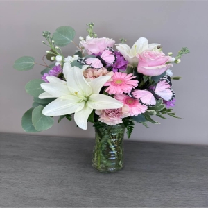 Blooms of Wayne Wayne - Drift away on wings of delicate beauty with 'Pastel Butterfly'. This stunning floral arrangement is a symphony of soft hues and graceful shapes designed to evoke feelings of peace joy and quiet romance. Imagine this piece gracing your dining table adding a touch of ethereal charm to a special occasion or simply brightening a loved one's day with an unexpected gesture of affection. The airy composition features a playful cascade of blooms resembling a butterfly in flight—light whimsical and utterly captivating. 'Pastel Butterfly' isn't just flowers; it’s a moment of serenity delivered perfect for expressing sympathy celebrating a new beginning or sending a sweet 'thinking of you'. This luxurious bouquet makes a beautiful centerpiece or a thoughtful gift for birthdays anniversaries or to show someone they are cherished.