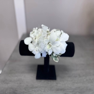 Blooms of Wayne Wayne - Drape yourself in the timeless elegance of our White Orchid Corsage. This stunning piece isn't just an accessory; it's a whisper of sophistication perfect for proms weddings or any special occasion demanding a touch of refined beauty. The cool smooth petals of the pristine white orchids feel like silk against your skin while their delicate fragrance subtly enhances your presence. Carefully designed with lush greenery this corsage creates a harmonious balance of texture and form offering a look that is both classic and contemporary. Imagine the soft glow of candlelight highlighting the purity of the blooms as you dance the night away or the sweet gesture of presenting this corsage to someone you cherish. A symbol of love admiration and lasting grace our White Orchid Corsage is a beautiful way to celebrate life’s most precious moments.