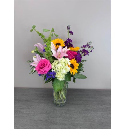 Blooms of Wayne Wayne - Breathe in the sunshine with 'Summer Vibing' a vibrant bouquet designed to capture the effortless joy of long summer days. This stunning arrangement bursts with the relaxed energy of the season offering a cheerful splash of color and fragrance to any space. Imagine the delicate scent of lilies and the playful pops of sunflowers brightening your kitchen table or the delighted smile of a loved one as they receive this thoughtful gift. 'Summer Vibing' isn’t just flowers; it’s a feeling – a little piece of happiness delivered straight to their door. Perfect for birthdays thank you gifts or simply to spread some warmth this bouquet embodies the carefree spirit of summer. Order yours today and let the good times bloom!