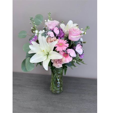 Blooms of Wayne Wayne - Drift away on wings of delicate beauty with 'Pastel Butterfly'. This stunning floral arrangement is a symphony of soft hues and graceful shapes designed to evoke feelings of peace joy and quiet romance. Imagine this piece gracing your dining table adding a touch of ethereal charm to a special occasion or simply brightening a loved one's day with an unexpected gesture of affection. The airy composition features a playful cascade of blooms resembling a butterfly in flight—light whimsical and utterly captivating. 'Pastel Butterfly' isn't just flowers; it’s a moment of serenity delivered perfect for expressing sympathy celebrating a new beginning or sending a sweet 'thinking of you'. This luxurious bouquet makes a beautiful centerpiece or a thoughtful gift for birthdays anniversaries or to show someone they are cherished.