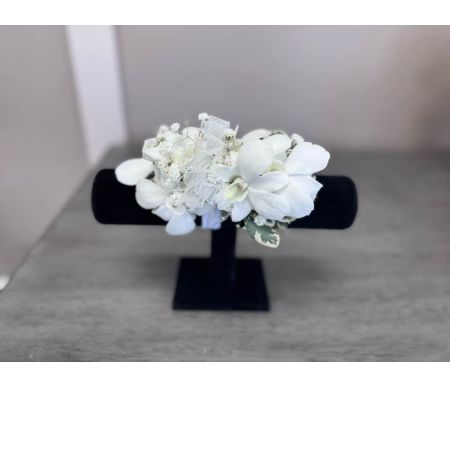 Blooms of Wayne Wayne - Drape yourself in the timeless elegance of our White Orchid Corsage. This stunning piece isn't just an accessory; it's a whisper of sophistication perfect for proms weddings or any special occasion demanding a touch of refined beauty. The cool smooth petals of the pristine white orchids feel like silk against your skin while their delicate fragrance subtly enhances your presence. Carefully designed with lush greenery this corsage creates a harmonious balance of texture and form offering a look that is both classic and contemporary. Imagine the soft glow of candlelight highlighting the purity of the blooms as you dance the night away or the sweet gesture of presenting this corsage to someone you cherish. A symbol of love admiration and lasting grace our White Orchid Corsage is a beautiful way to celebrate life’s most precious moments.