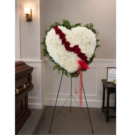 Blooms of Wayne Wayne - Express profound sympathy and enduring love with our ‘Broken Heart with Rose Break’ arrangement. This poignant bouquet speaks volumes when words fall short offering solace and remembrance during difficult times. Crafted with a delicate balance of beauty and grief it features a fractured heart shape overflowing with a cascade of soft blooms. Imagine the quiet comfort it brings standing vigil on a bedside table or offering a gentle embrace at a memorial.  The rich textures and subtle fragrance create a calming presence a visual hug for someone navigating loss. This is more than just flowers; it’s a gesture of heartfelt understanding and lasting support.  Send this stunning piece to let them know they are not alone and their loved one will be forever cherished. Perfect for funerals sympathy gifts or simply expressing your deepest condolences.