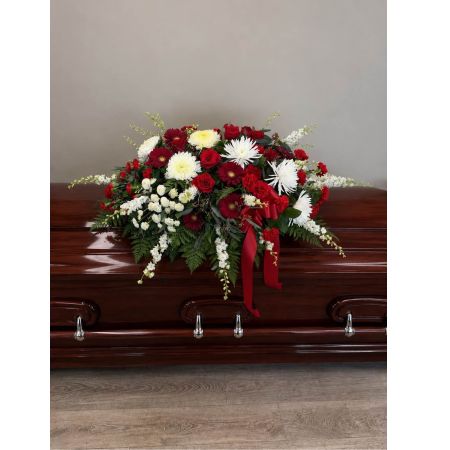 Blooms of Wayne Wayne - Express your deepest sympathy and reverence with our Red and White Casket Spray. This stunning tribute is a beautiful cascade of vibrant red roses and pristine white larkspur designed to offer comfort and peace during a difficult time. The rich scarlet blooms represent the love and respect you hold for the departed while the pure white flowers symbolize the peace they have found.  The arrangement is thoughtfully crafted to create a sense of dignified beauty providing a visual embrace of remembrance.  Its generous size makes it a particularly appropriate expression of condolence for a funeral service or memorial.  Send a lasting message of heartfelt sorrow and enduring love with this beautiful spray – a poignant gesture to honor a life well-lived and provide solace to grieving hearts. This classic design is suitable for viewing and burial services.